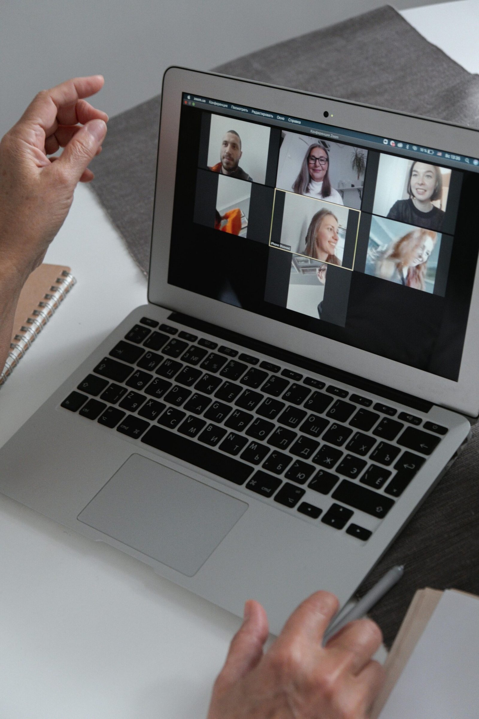 why-choose-us Hands at a laptop showing a group video call in a home office setting.